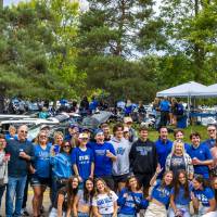 Large group of people poses for picture during Family Day tailgate.